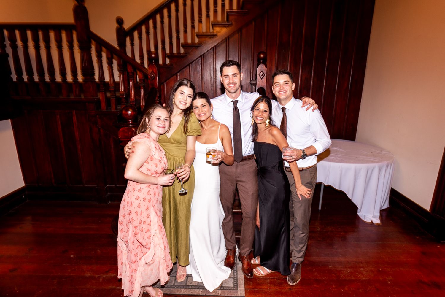 A group gathers on a wooden staircase during what appears to be a formal event or celebration.