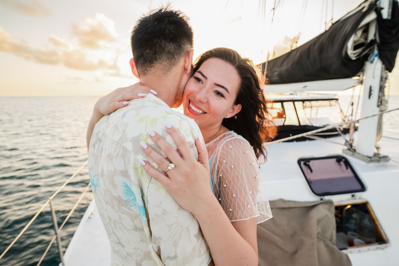 Romantic sunset embrace aboard a sailboat with golden light.
