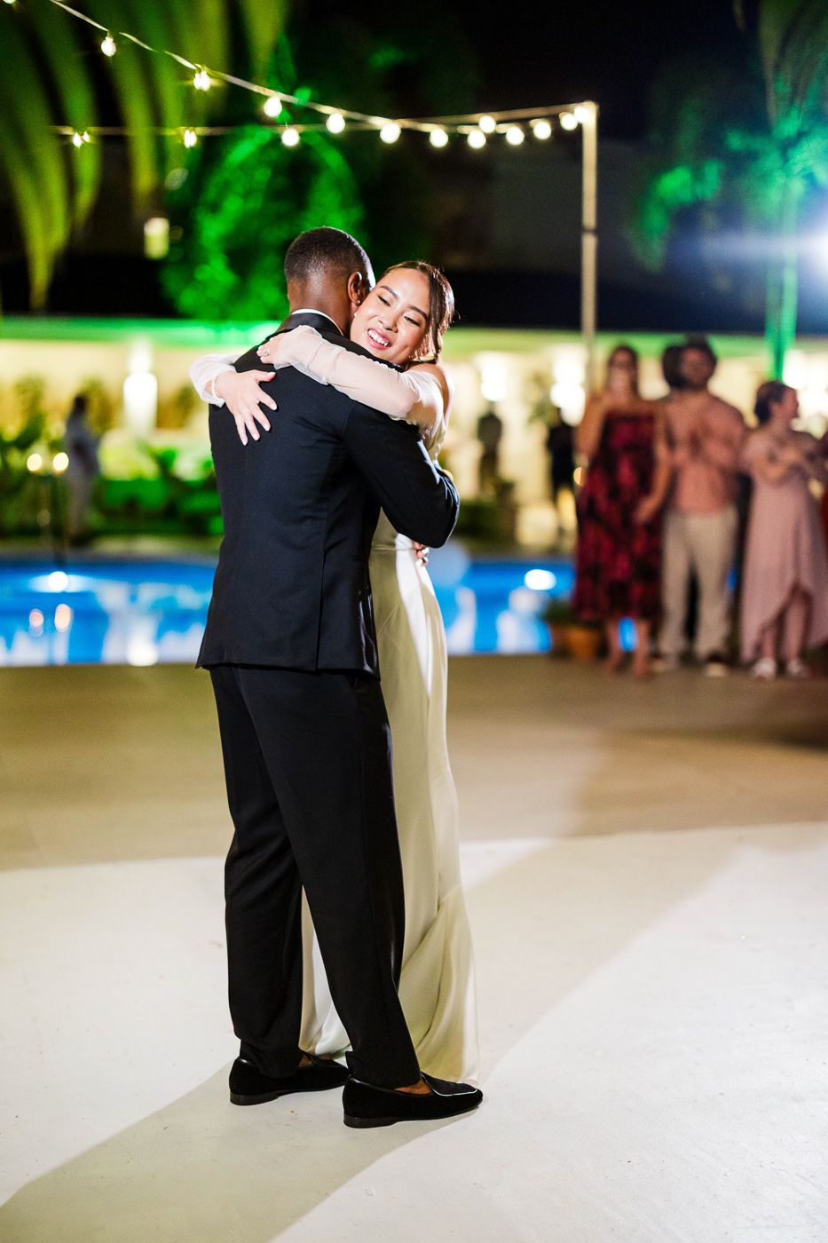 Dancing couples enjoy romantic moments on an illuminated outdoor dance floor.