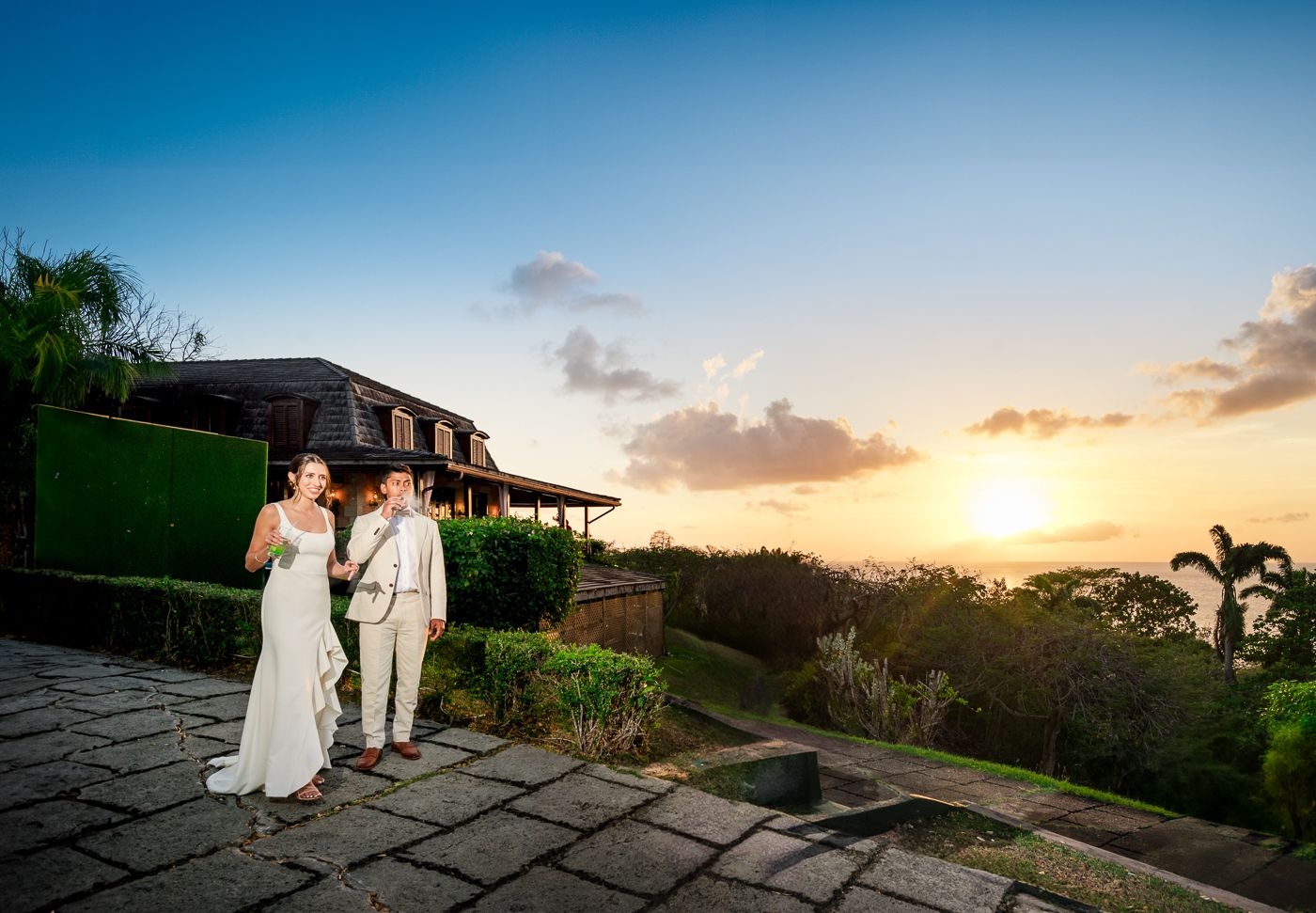 Beautiful sunset view from a stone patio overlooking tropical landscape.