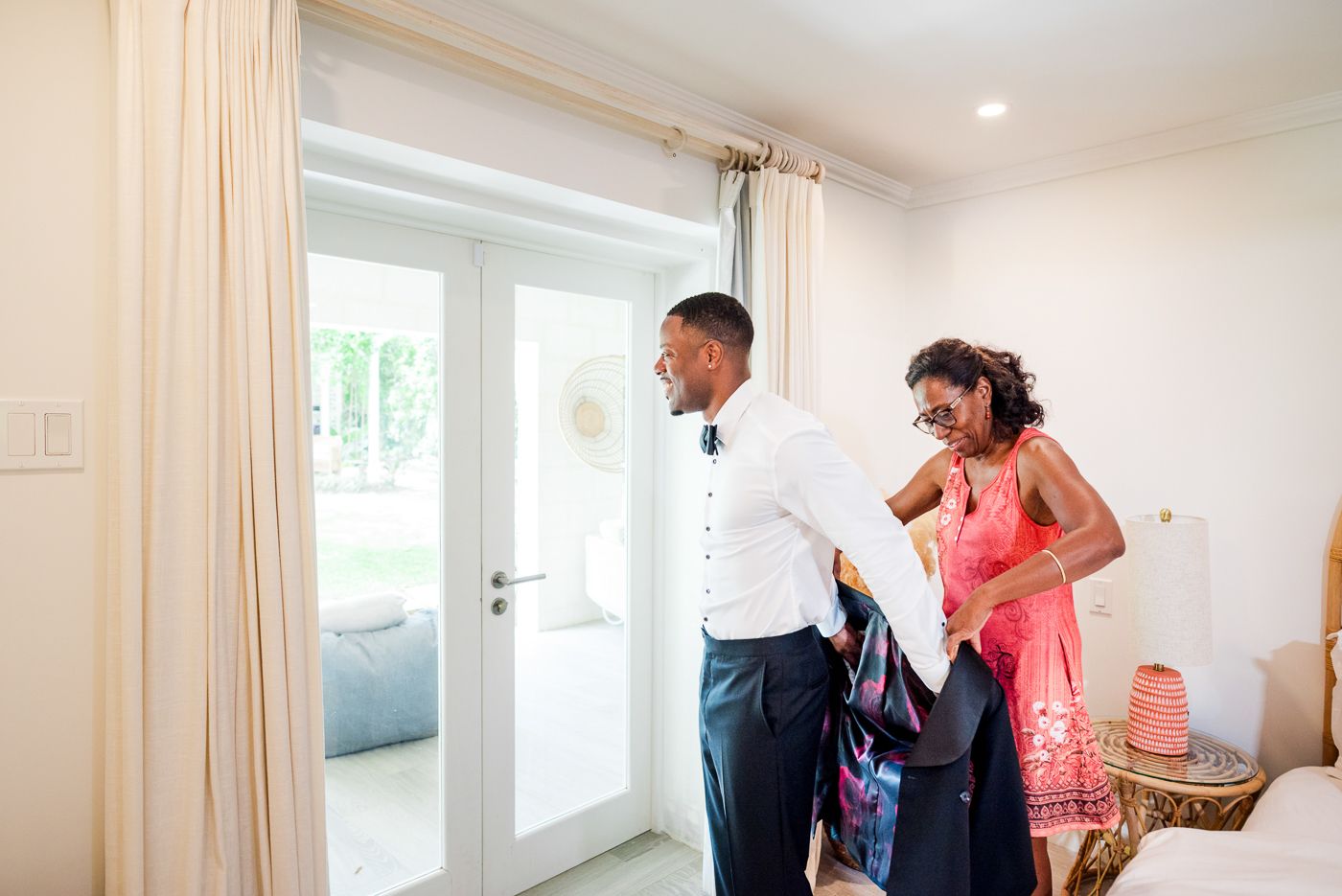 Wedding preparation scene in a bright modern room with cream curtains.