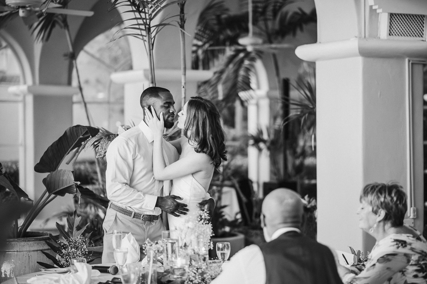 Wedding reception speech moment captured in black and white at an elegant tropical venue.