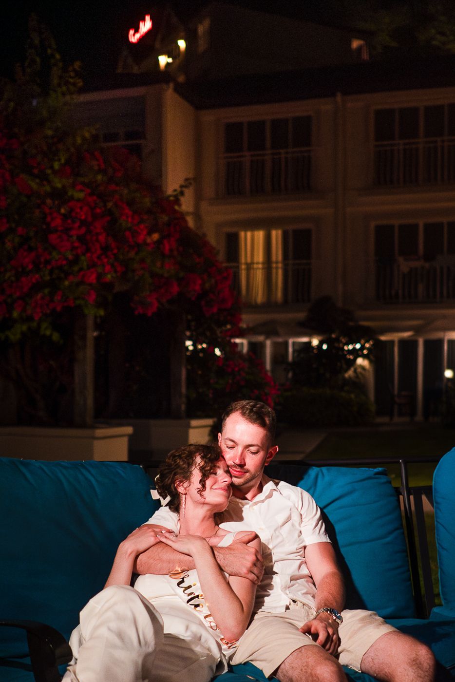 Intimate moment shared on a blue outdoor couch during an evening celebration.