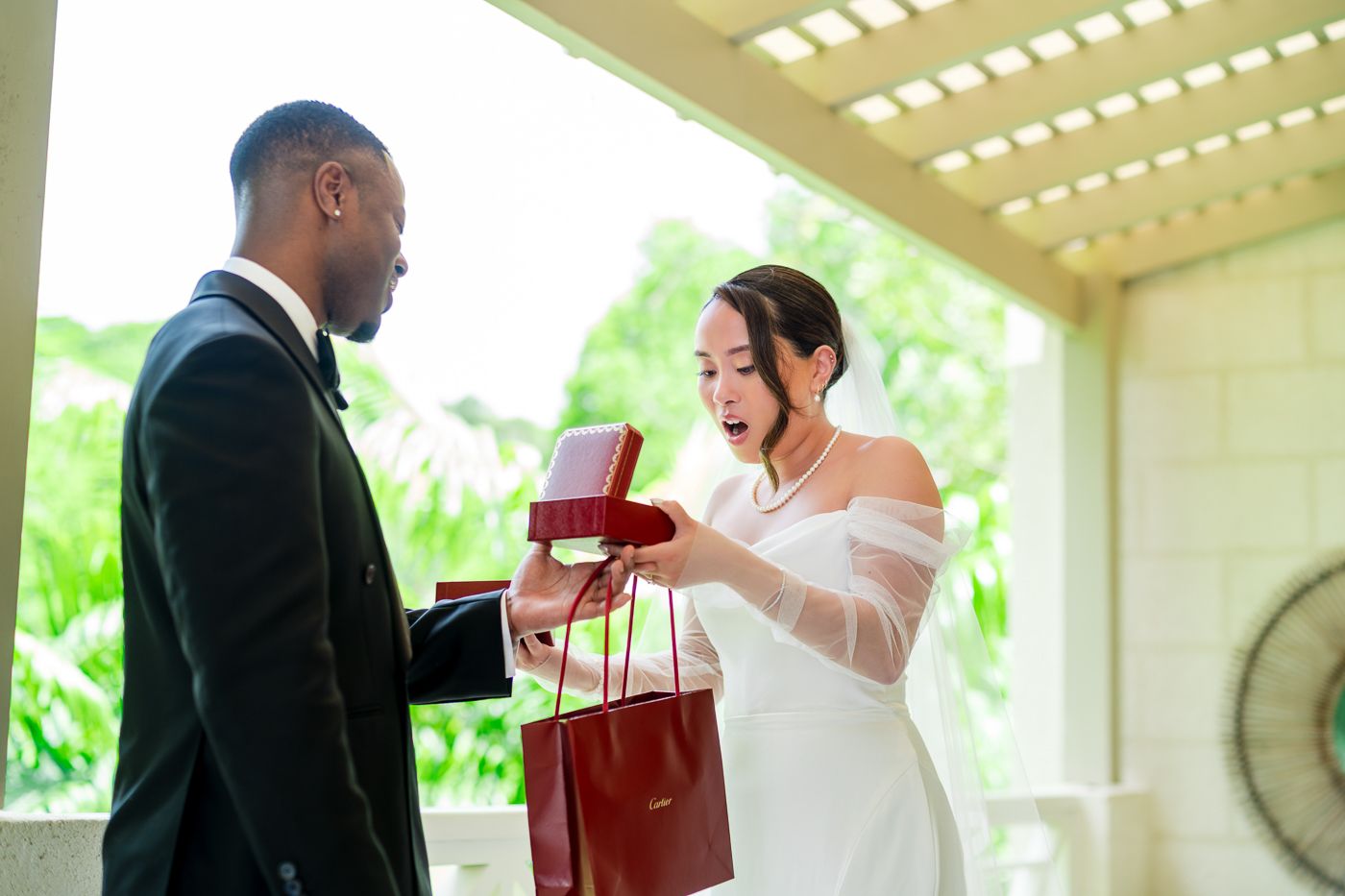 A wedding gift exchange captured on a bright veranda with tropical garden views.