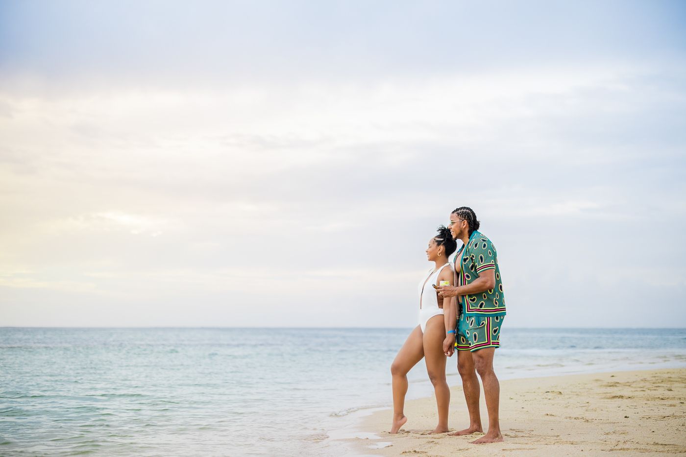 Romantic couple embracing on a beach at sunset with ocean waves in the background. Nomans land in tobago