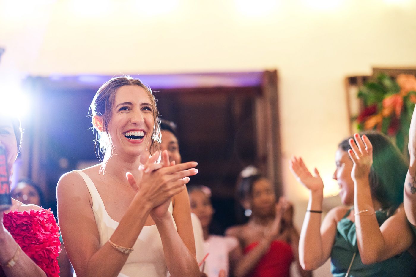 A joyous celebration captured during an indoor wedding reception with bright lighting.