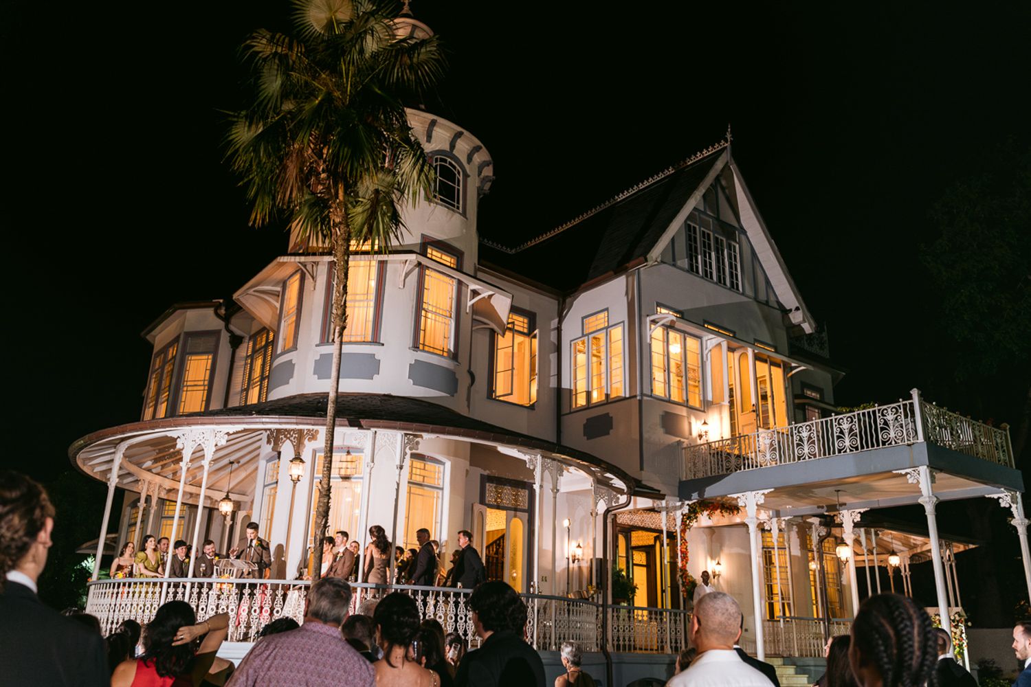 Historic Victorian mansion with glowing windows and wraparound porch illuminated at night in multiple dynamic views.