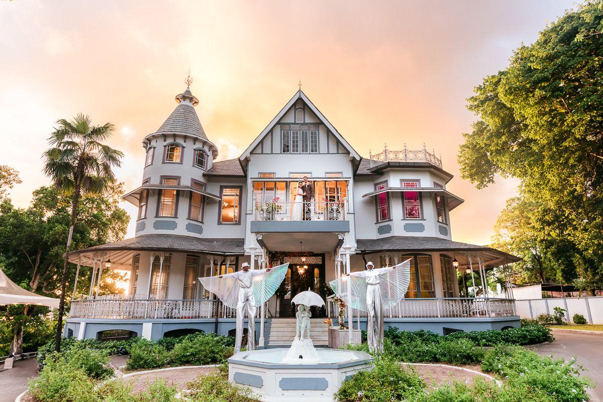 Beautiful Victorian mansion with turret and wraparound porch glows warmly at sunset in Mount Dora, Florida.