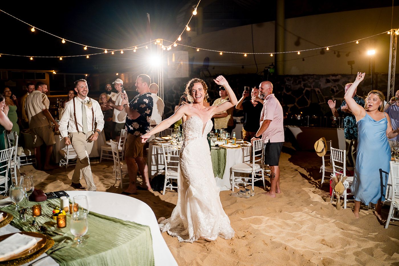 Evening beach wedding celebration with string lights and dancing under the stars.