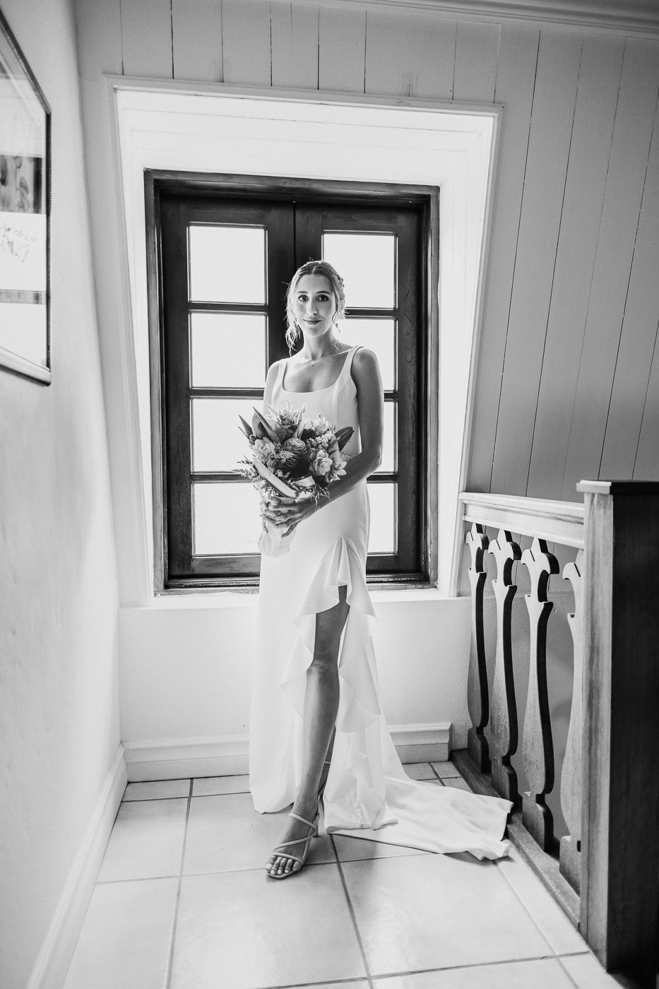 Black and white photography series showing bridal preparations in a minimalist white interior.
