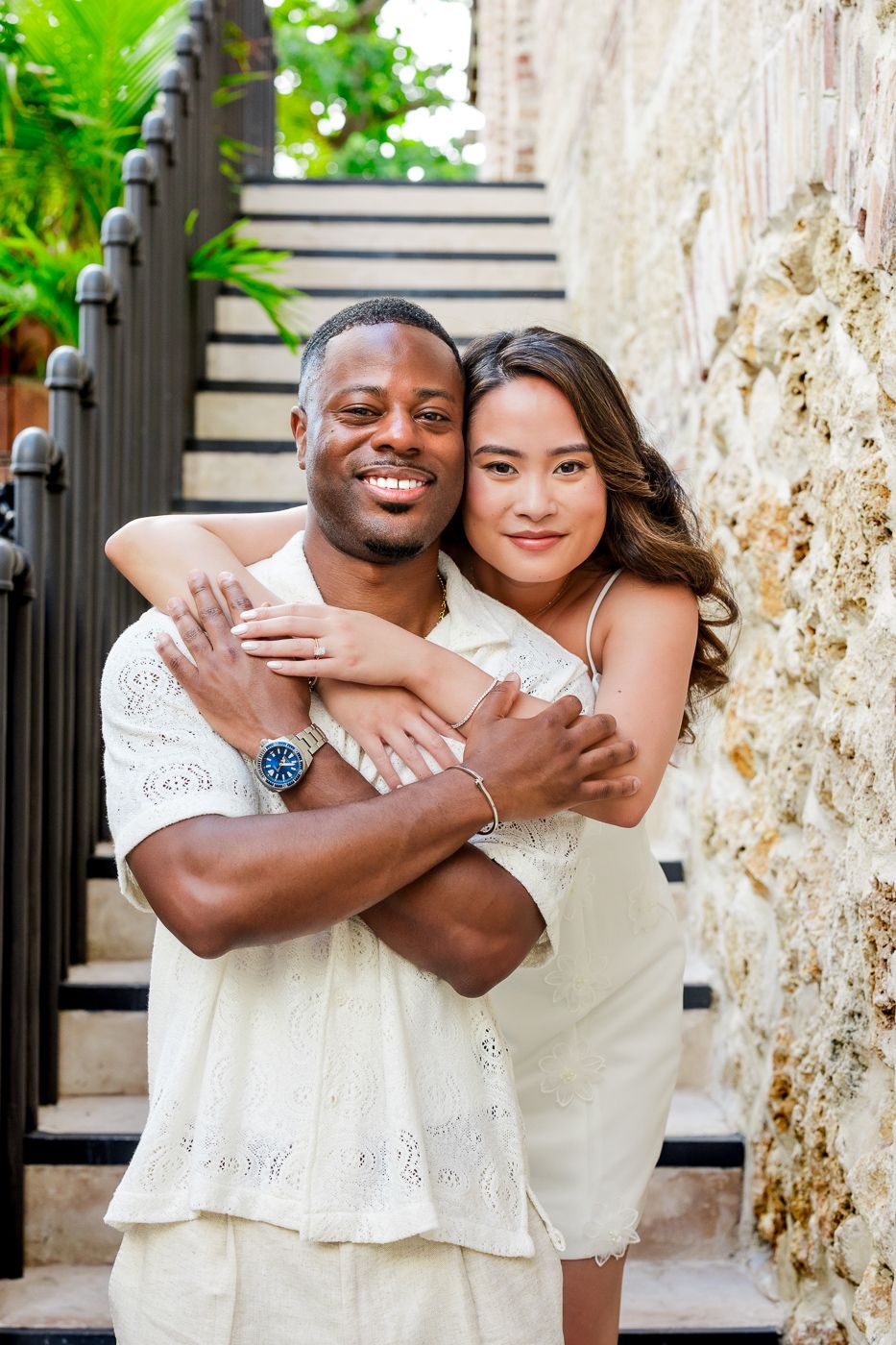 A loving couple shares a tender moment while posing together on outdoor steps.