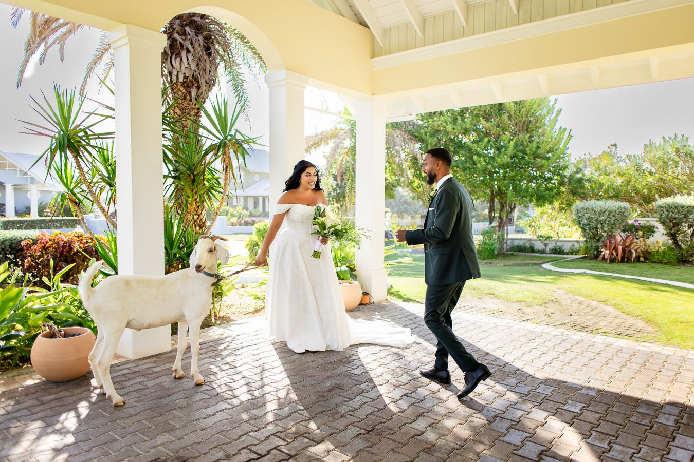 Wedding celebration on a covered tropical patio with yellow walls and stone flooring.