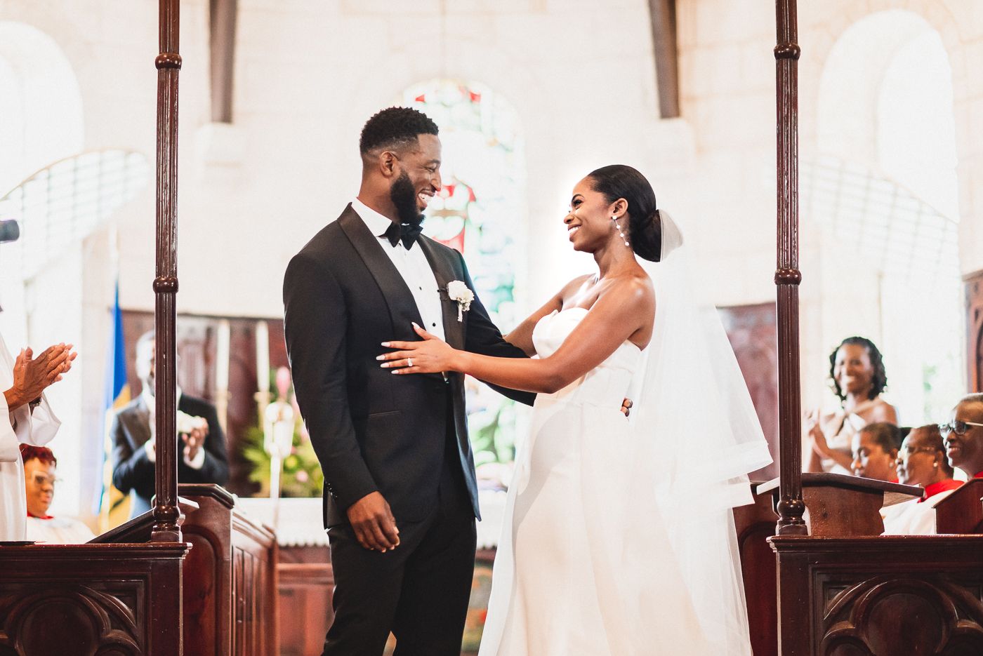 Emotional moment during church wedding ceremony with guests watching from pews.
