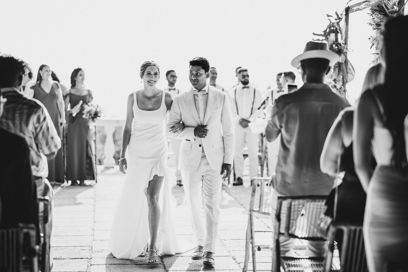 Black and white photo of wedding ceremony processional on outdoor terrace.
