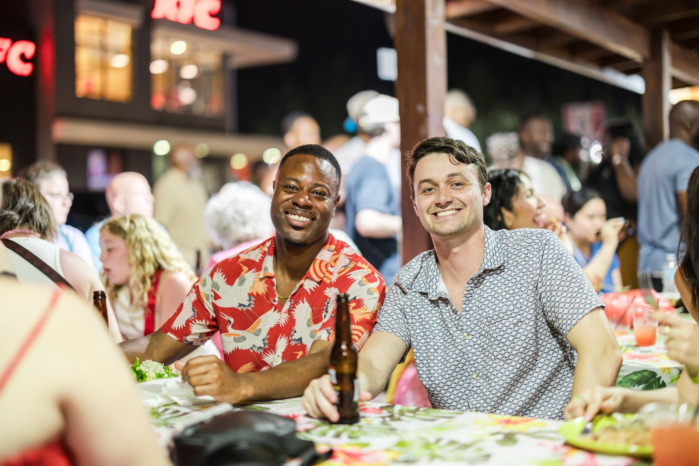Friends enjoying dinner outdoors at a casual restaurant setting.