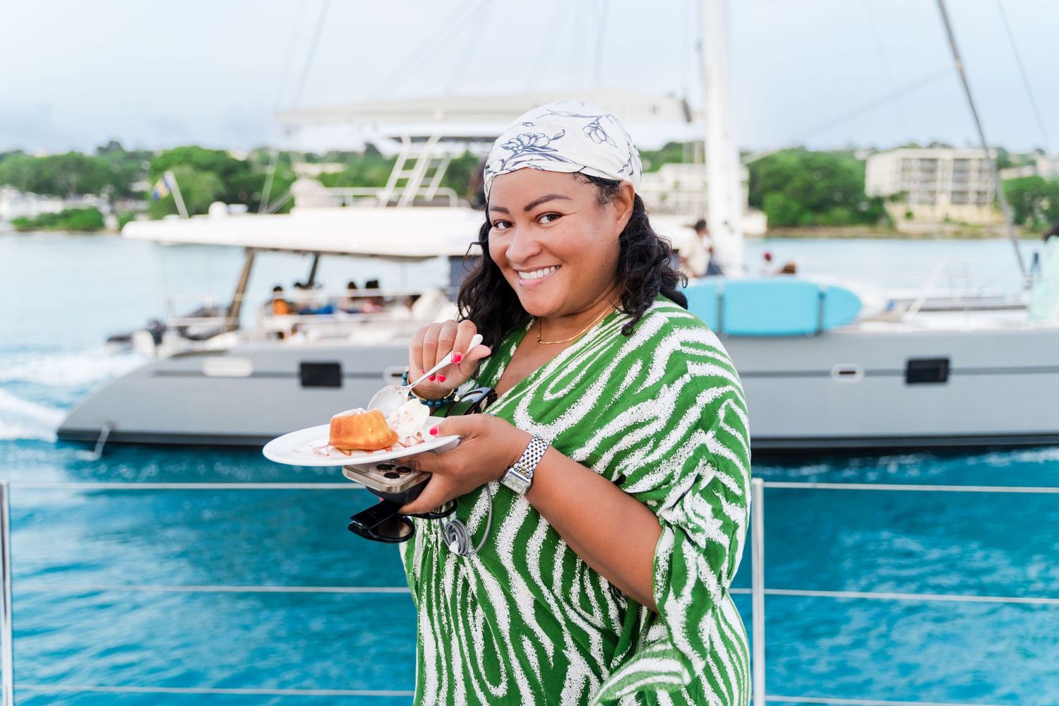 Diverse group enjoying tropical drinks and snacks aboard a luxury yacht in bright turquoise Barbados waters.