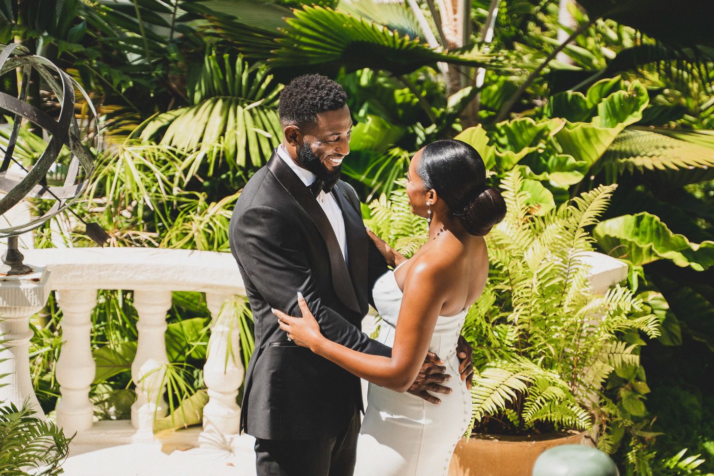 Intimate wedding moment captured in a tropical garden setting surrounded by lush greenery.