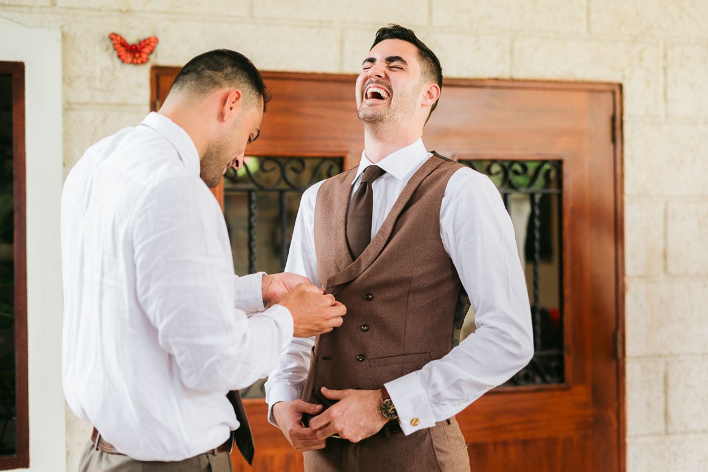 Candid moments of groomsmen laughing and sharing jokes during wedding preparations.