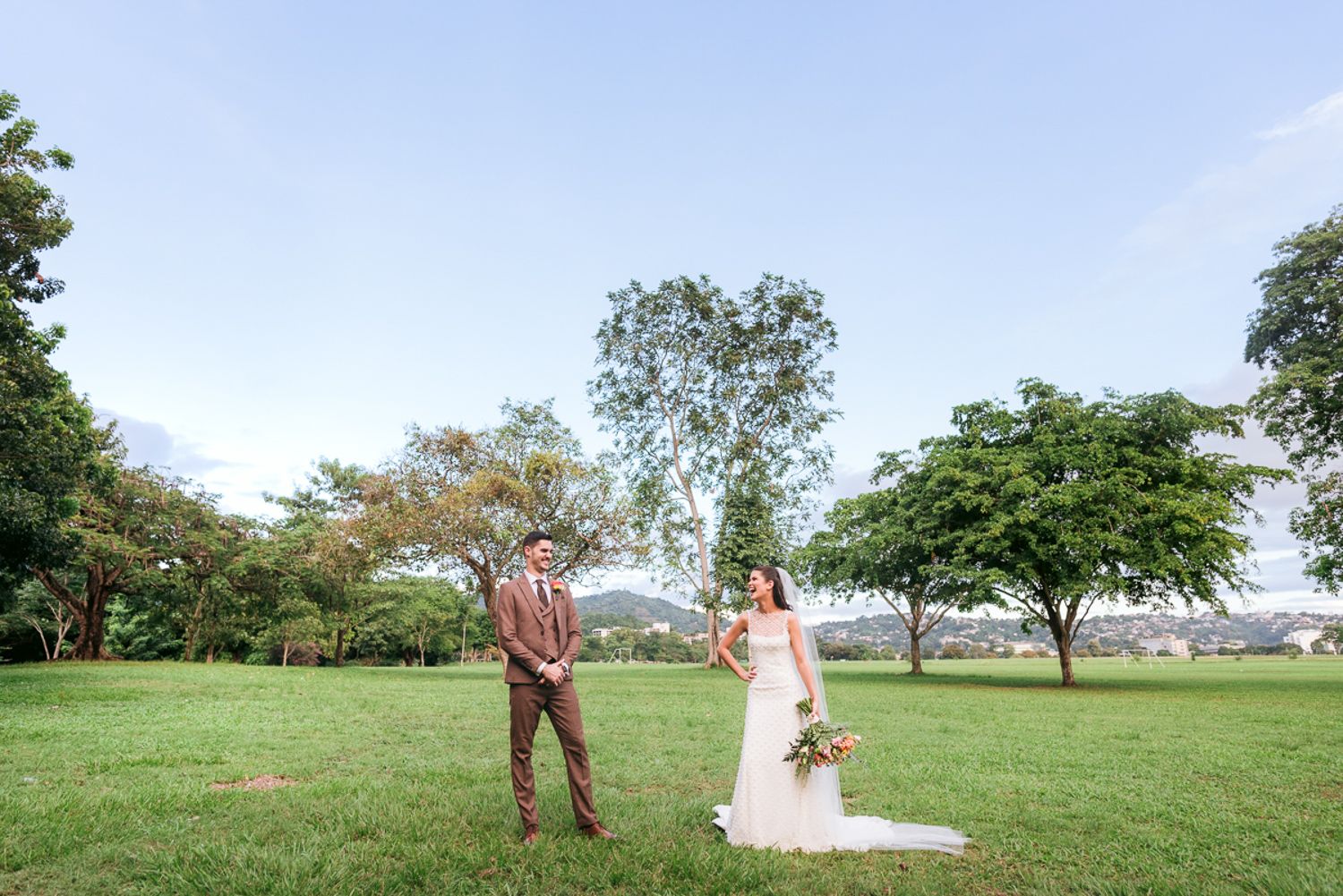 A collection of outdoor wedding photos showing couples in elegant attire posing together on a grassy hilltop.