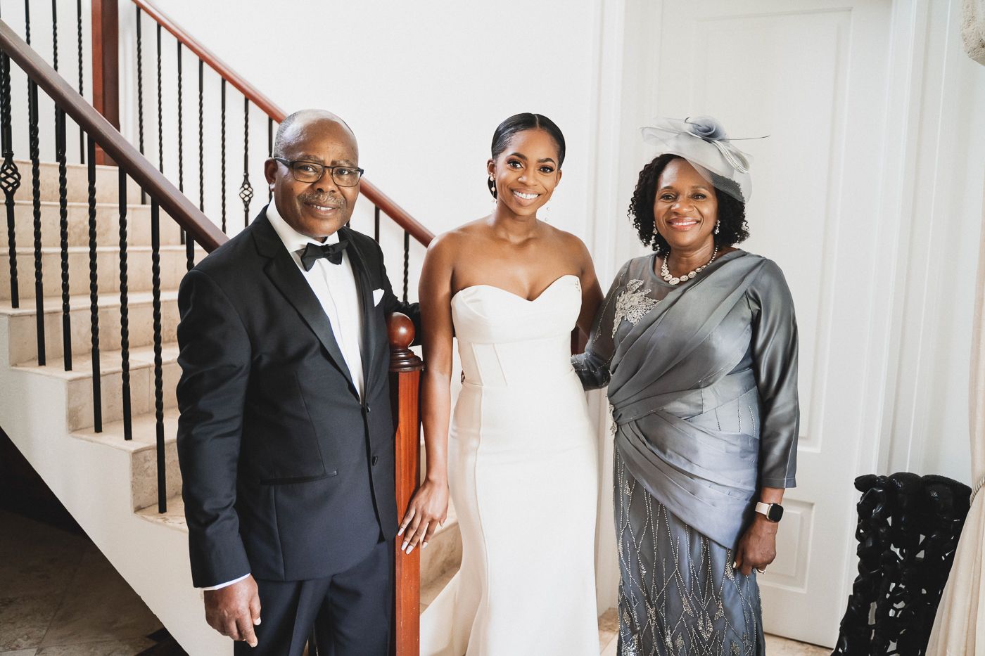 Wedding party portrait on grand staircase with classic interior design elements.