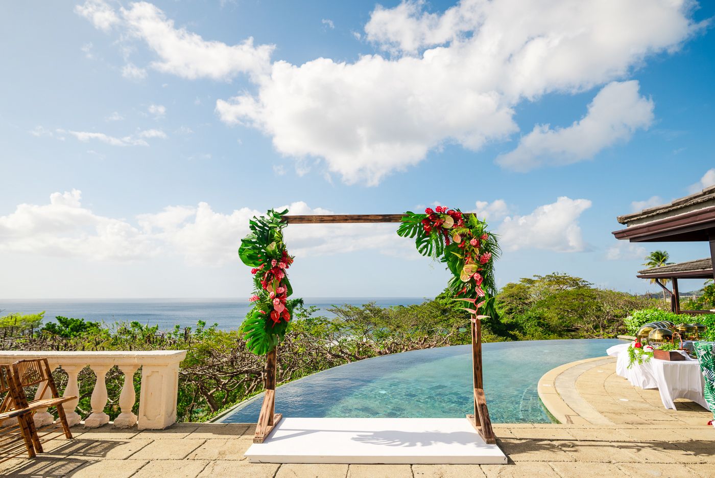 Panoramic view of a tropical ocean wedding arch setup against blue skies.