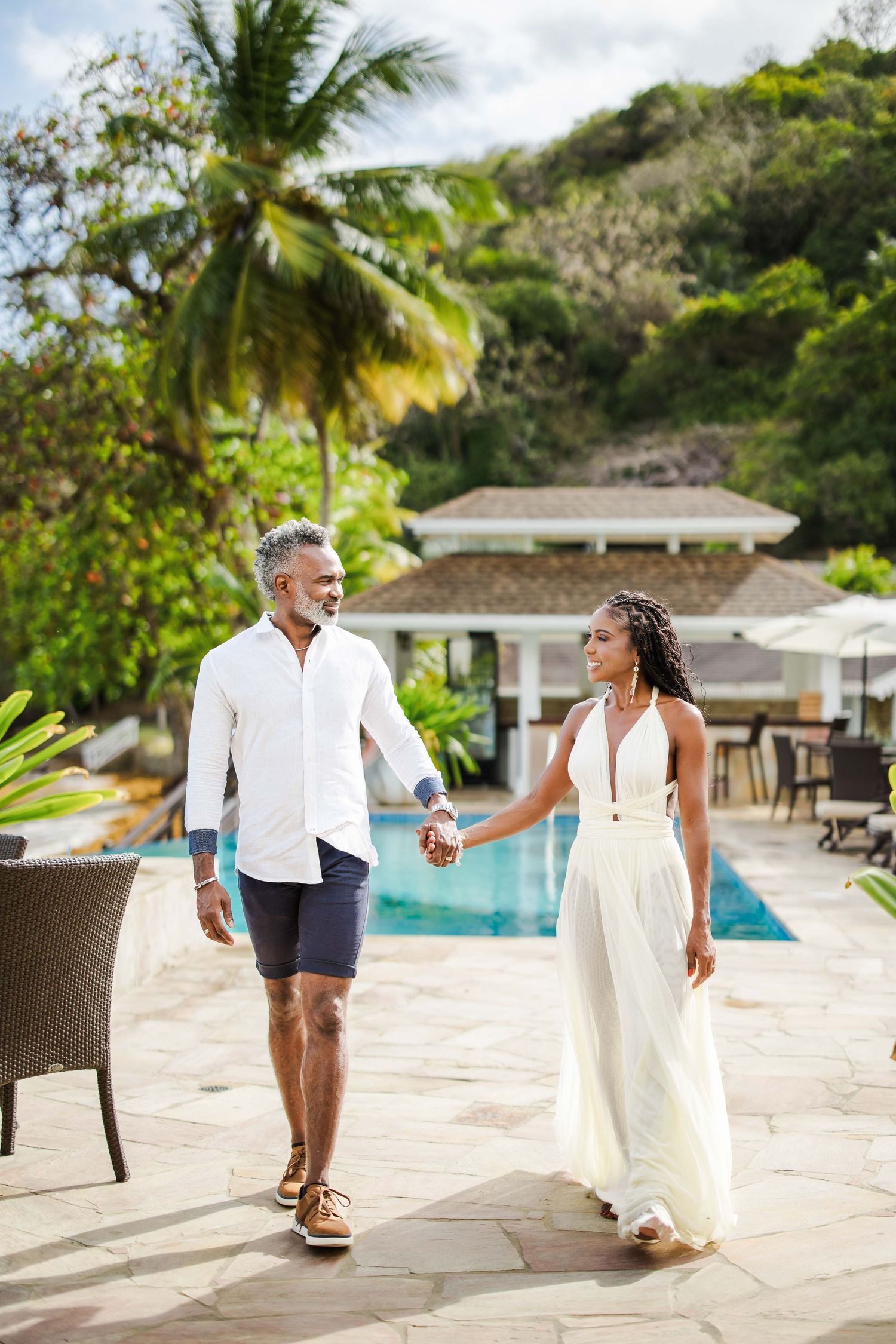 Romantic beachside wedding photos with palm trees and resort pool in background.