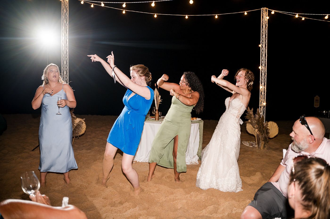 Wedding party jumps into ocean for late night swim celebration.