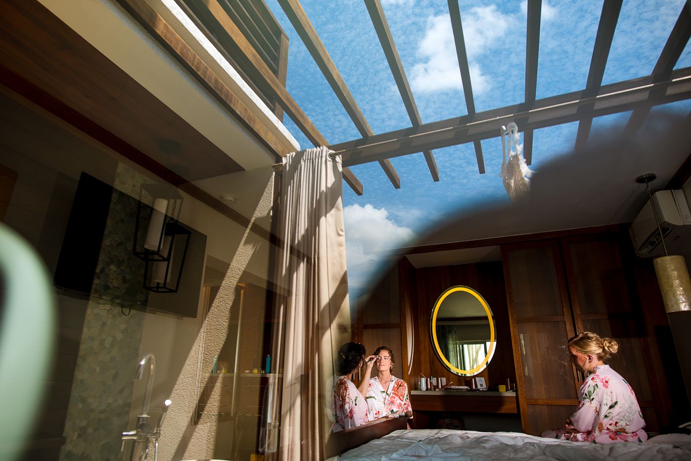 Interior view of a tropical resort room with wooden beams and natural lighting.