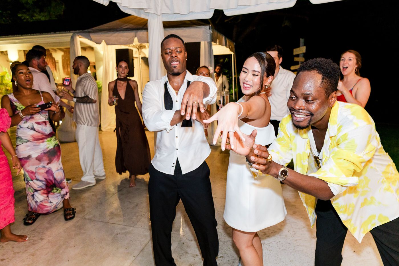 Wedding reception dance floor with guests in colorful attire enjoying the celebration.