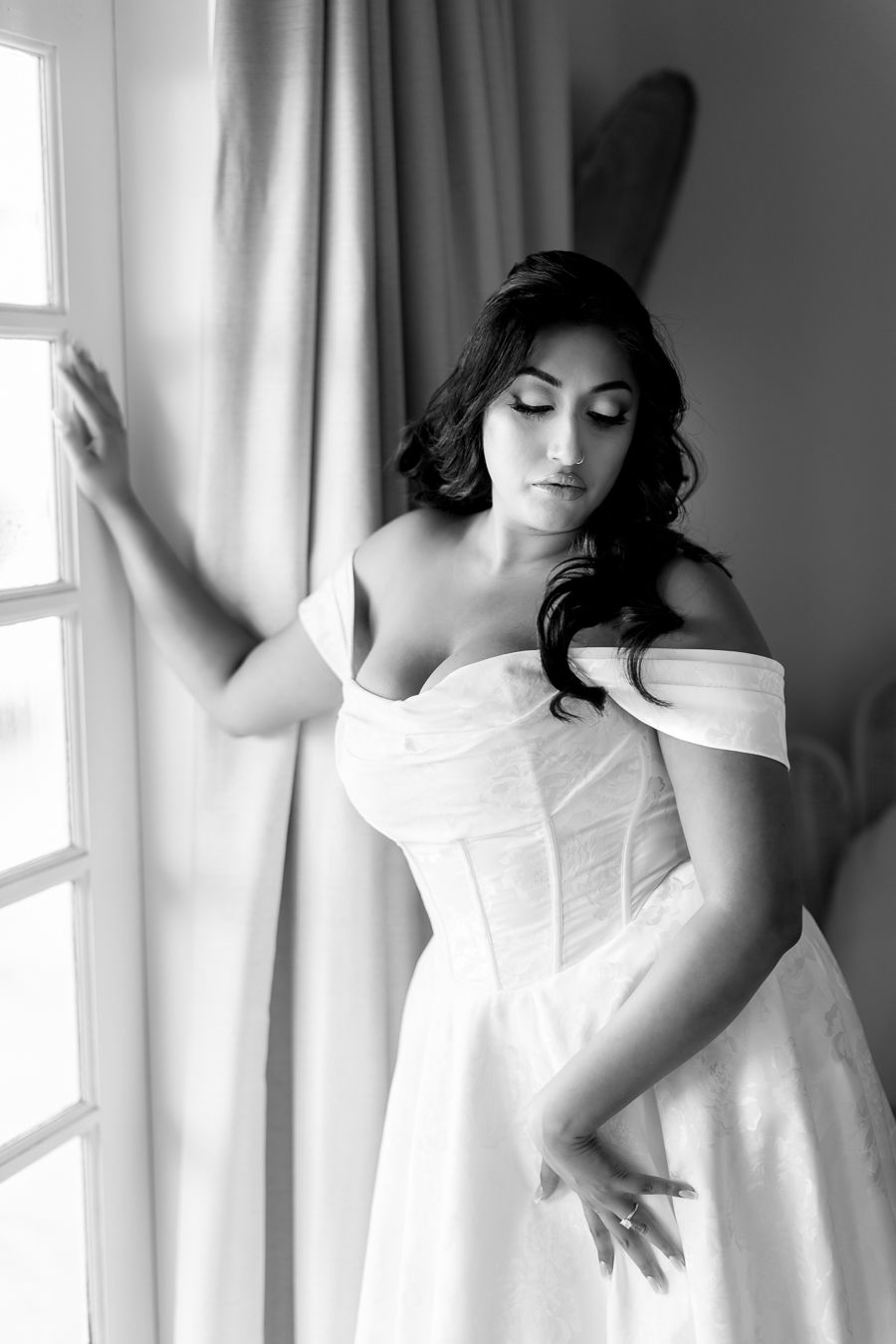 Artistic black and white series showing flowing white dress movement against window light.