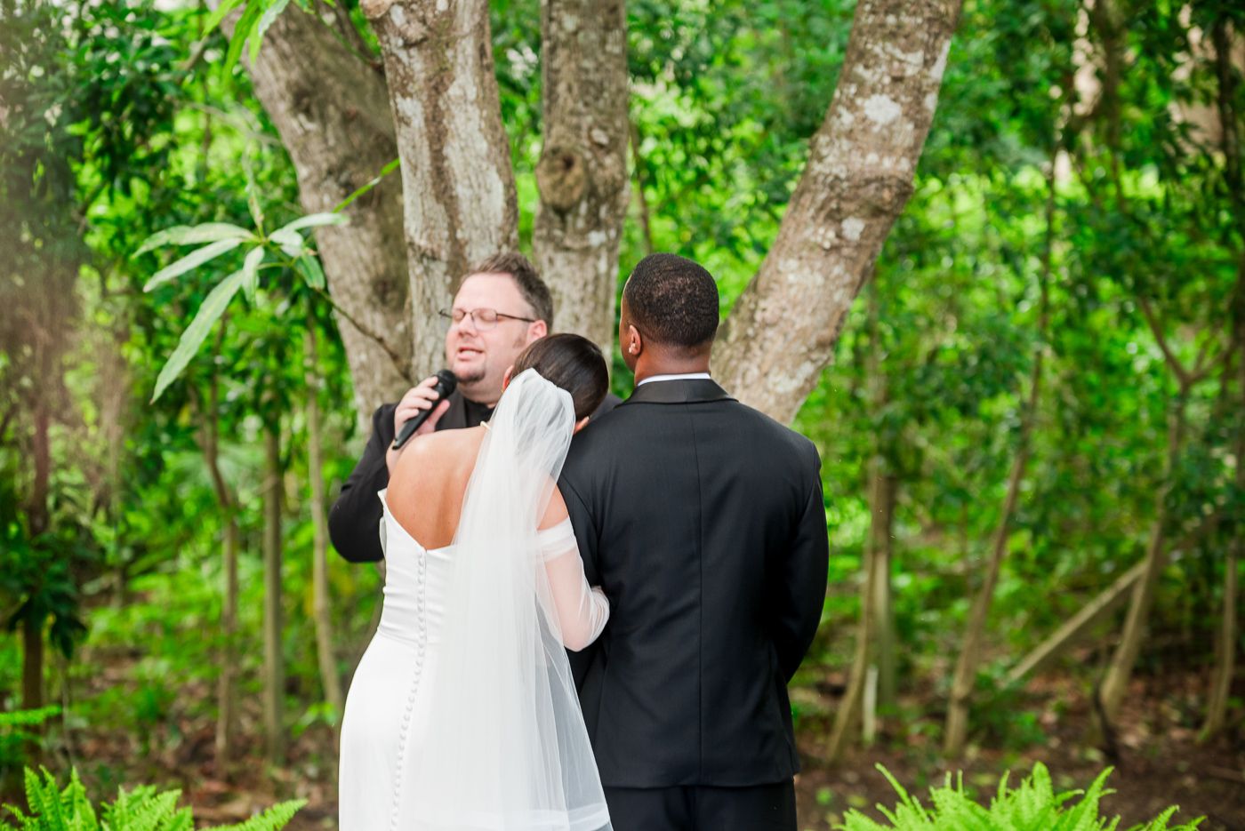 A couple shares an intimate first look moment in a lush garden setting during their wedding.