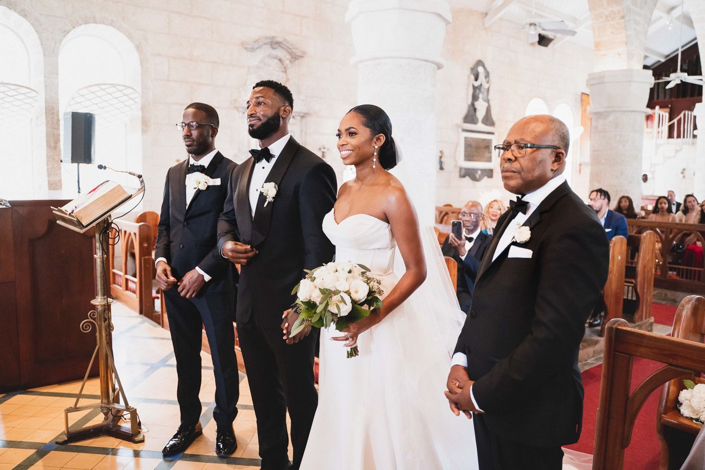 Traditional church wedding ceremony with elegant decor and stone arch architecture.