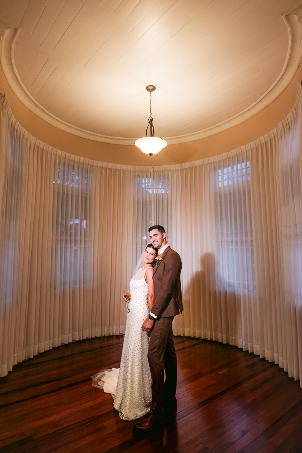 A series of five photos showing a couple dancing in a circular room with white curtains and hardwood floors.