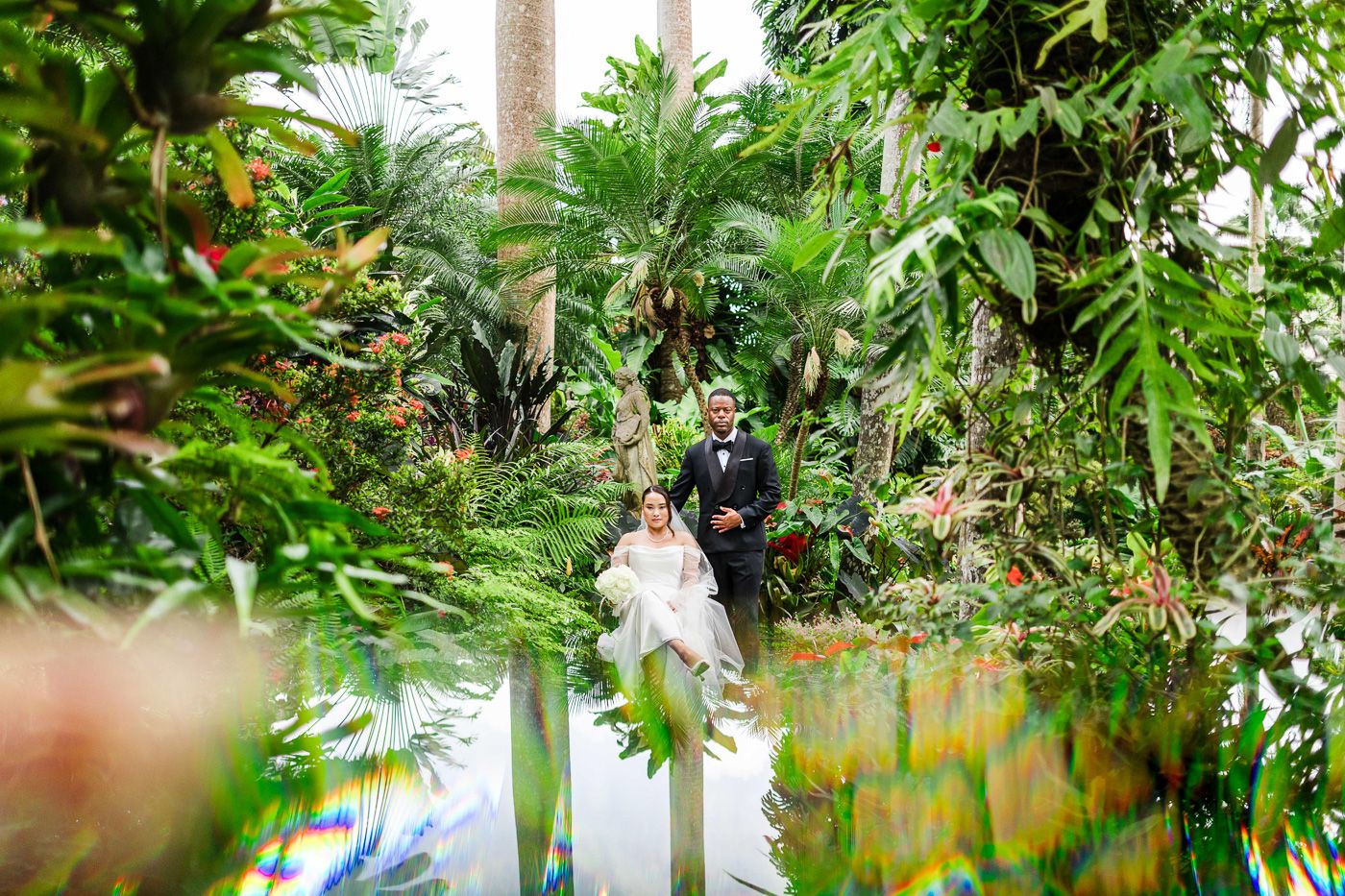 Wedding celebration amidst a tropical garden paradise with towering palm trees.