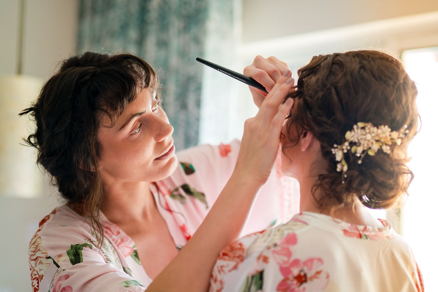 A group getting ready with makeup and hair styling before a special event in floral robes.