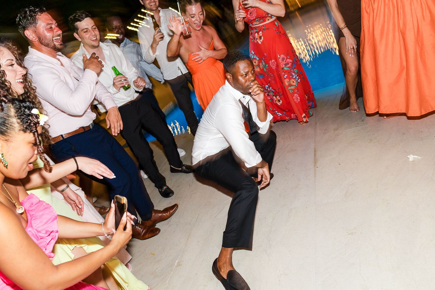 Energetic dance floor moments captured at a wedding reception with guests in formal attire.