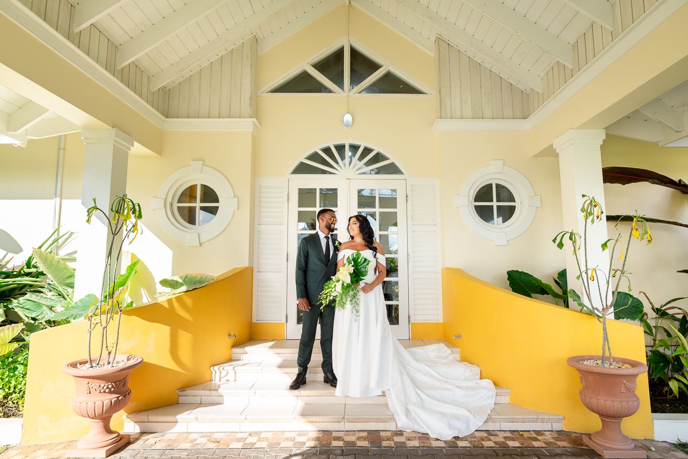 Interior shots of a tropical wedding venue with white columns and yellow accent walls.