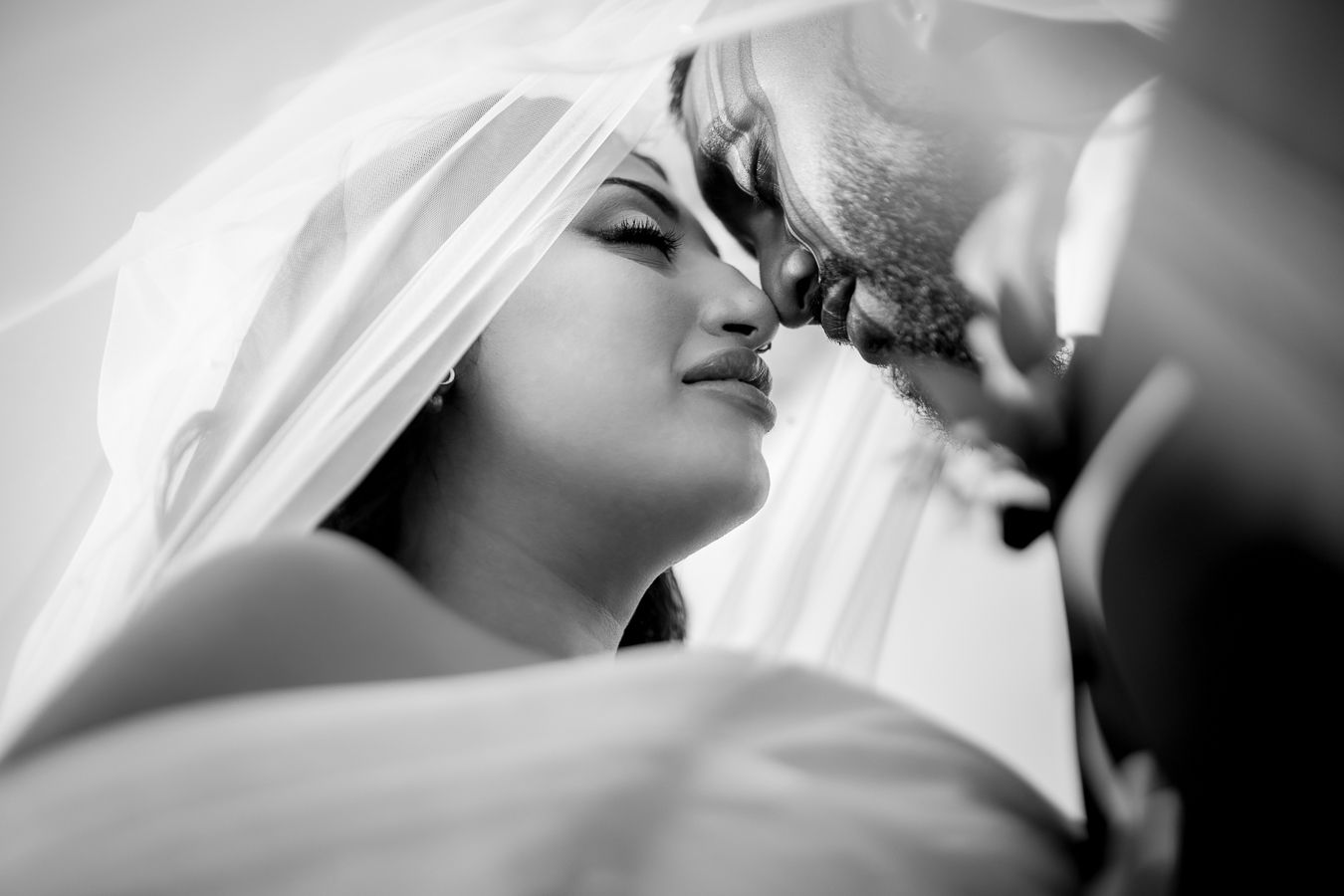 Ethereal black and white series showing romantic moments between newlyweds beneath flowing veil.