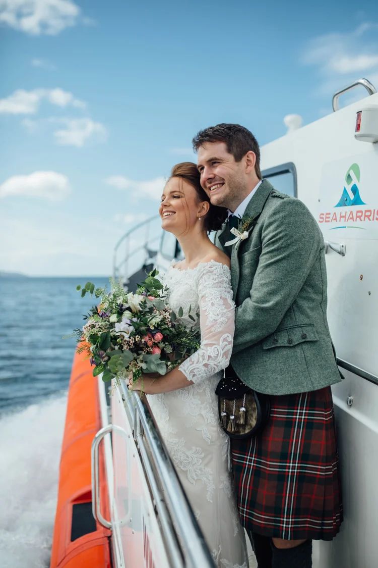 bride and groom embracing during outdoor wedding on a boat in Scotland