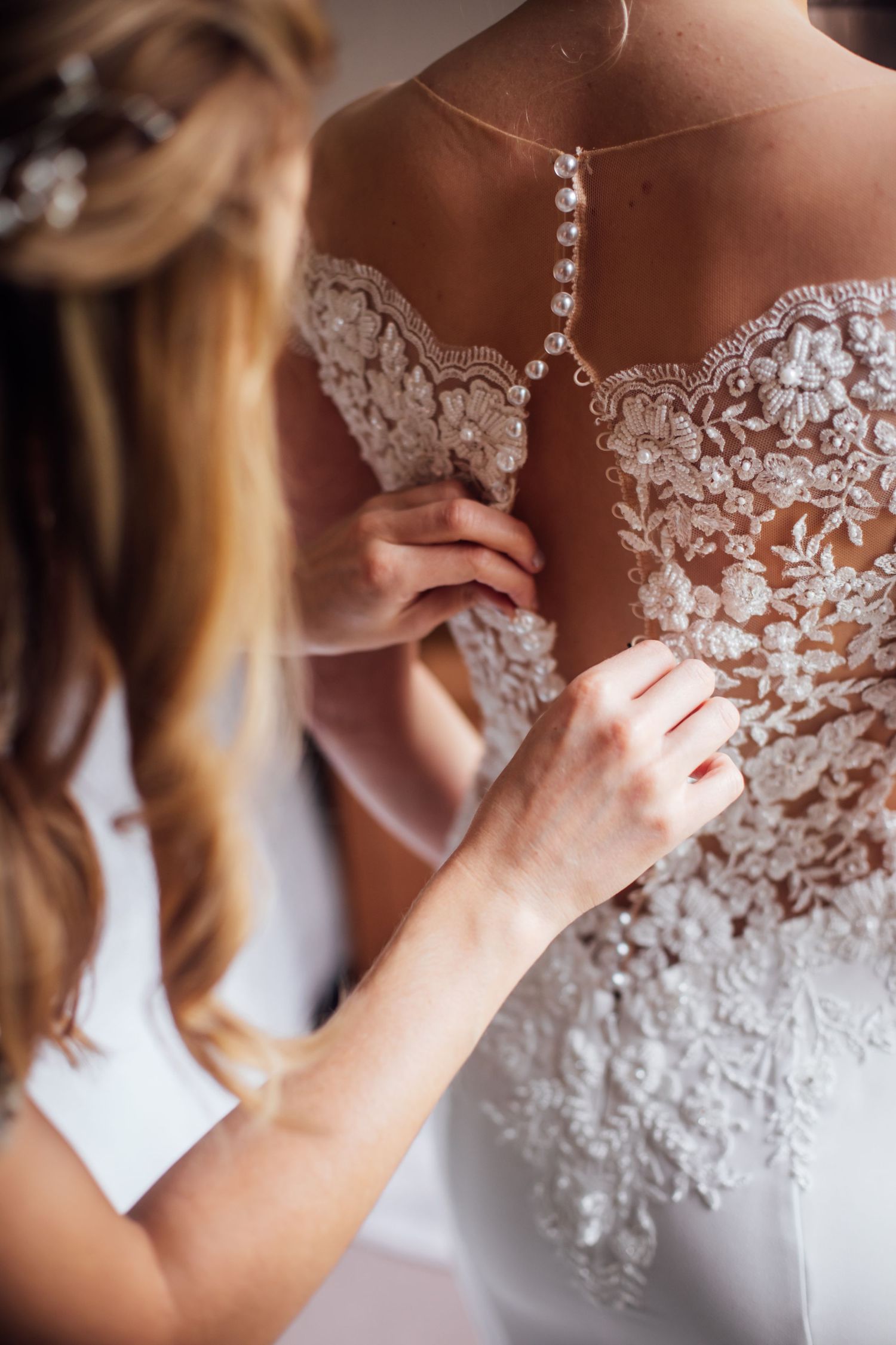 hands fixing wedding dress during bridal prep