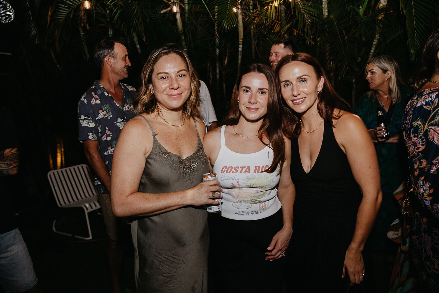 Guests enjoying themselves at a festive outdoor party with ambient lighting.
