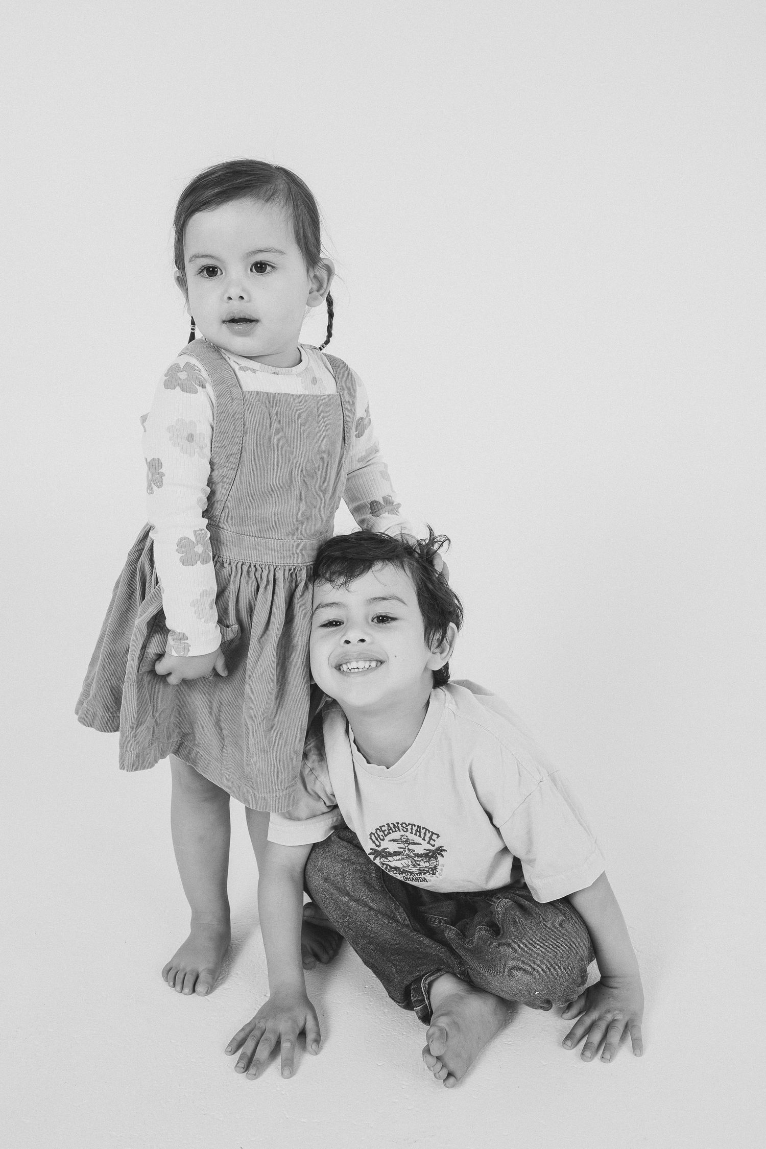 Black and white studio sequence of siblings playing and posing together.