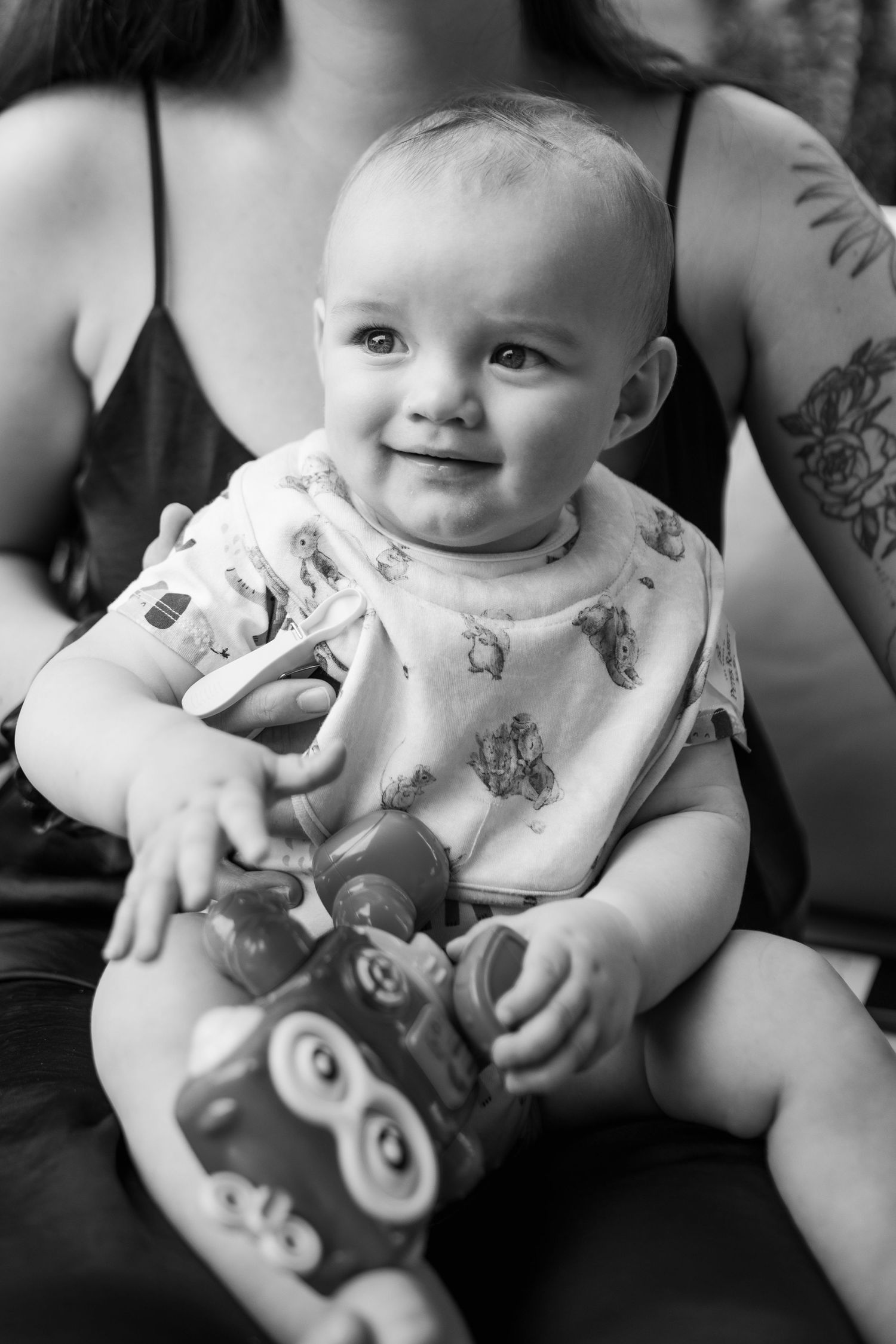 Black and white close-up photos of a baby playing with toys.