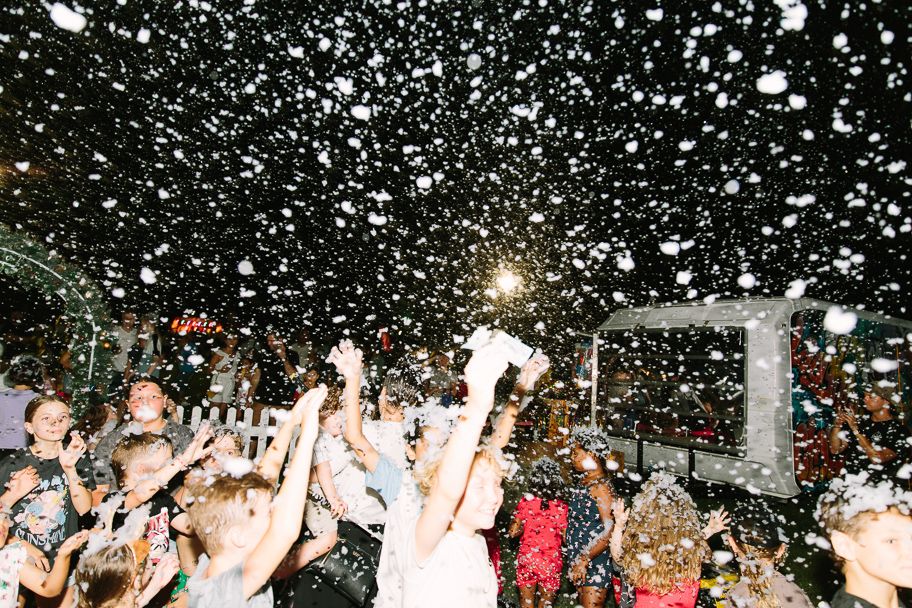 Confetti explosion at night event creates magical atmosphere over dancing crowd.