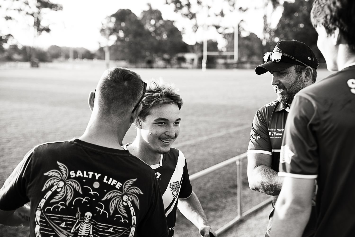 Rugby players gathered on the sidelines during a break in the game.