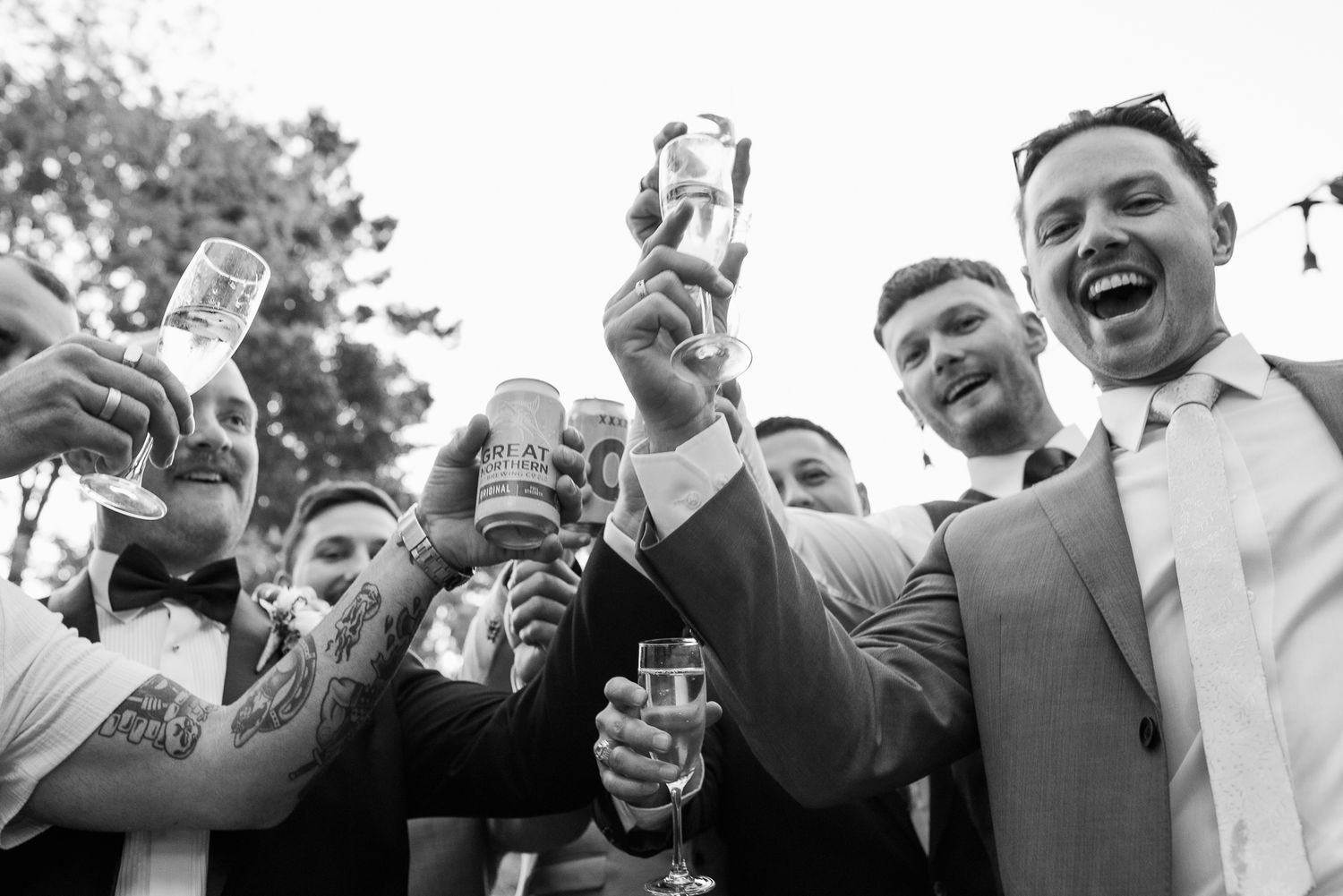 Black and white photos of wedding guests laughing and toasting during celebration.