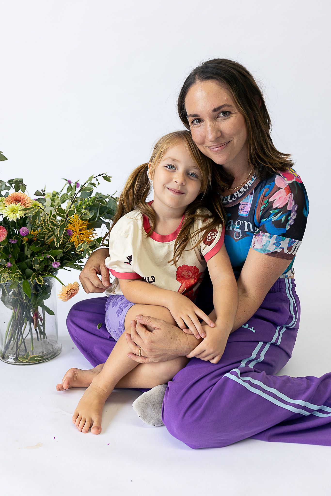A casual portrait session with flowers and purple decor on a white background.