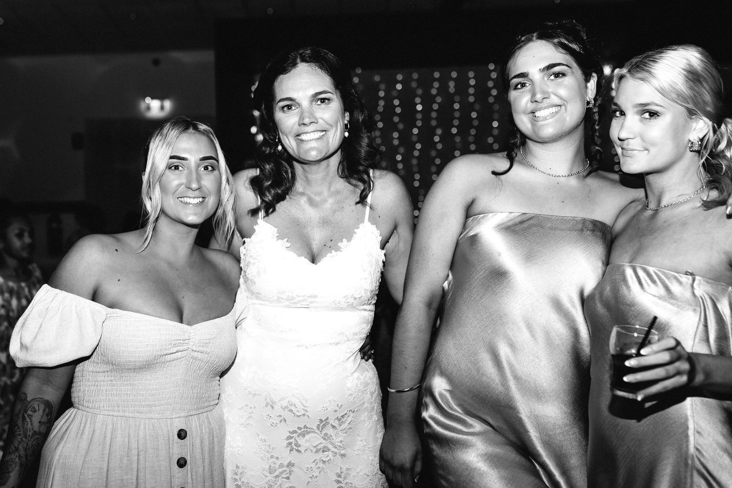 Black and white photo of wedding guests celebrating at a reception.