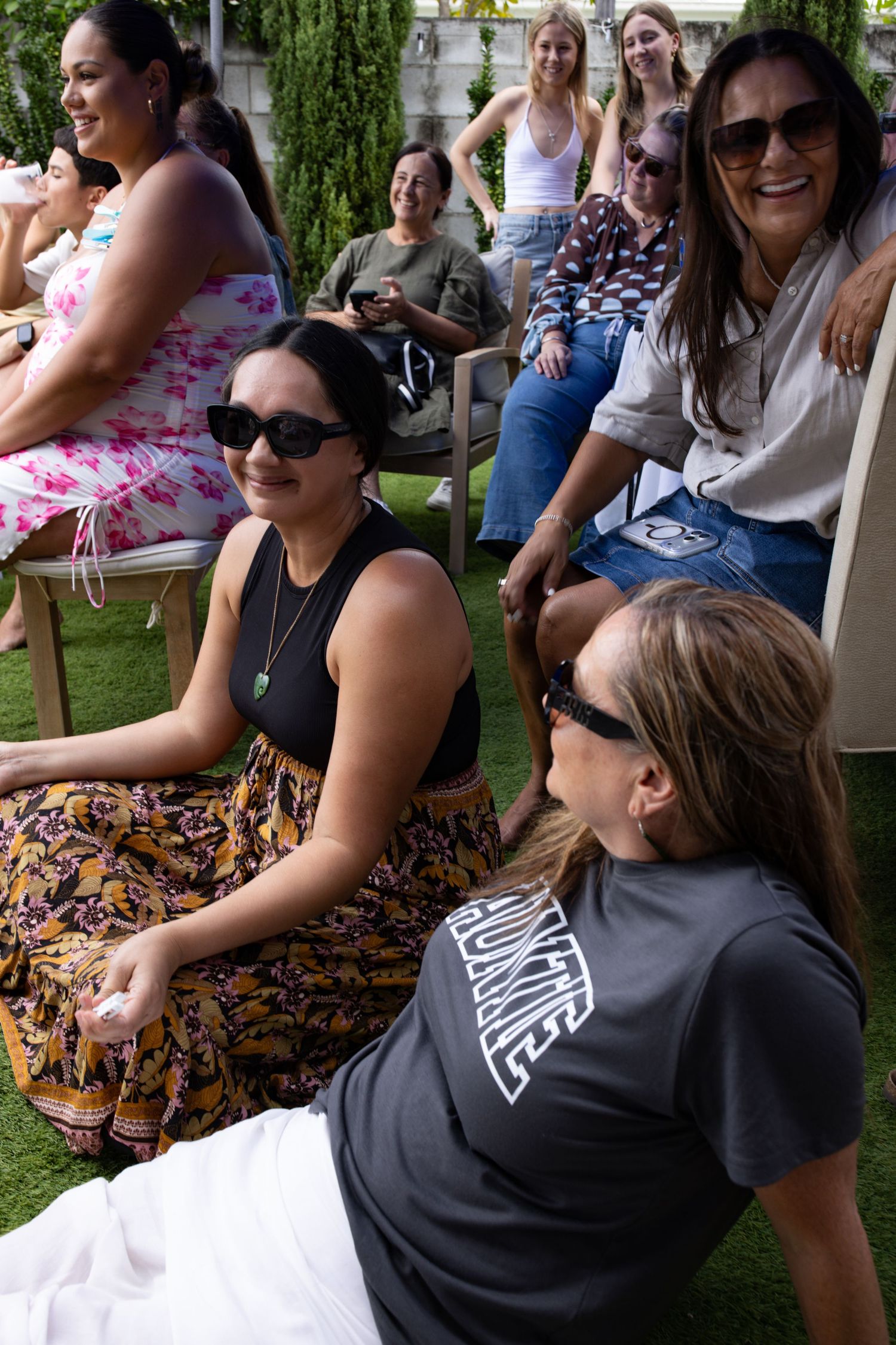 Group of friends relaxing outdoors on a porch during a casual gathering.
