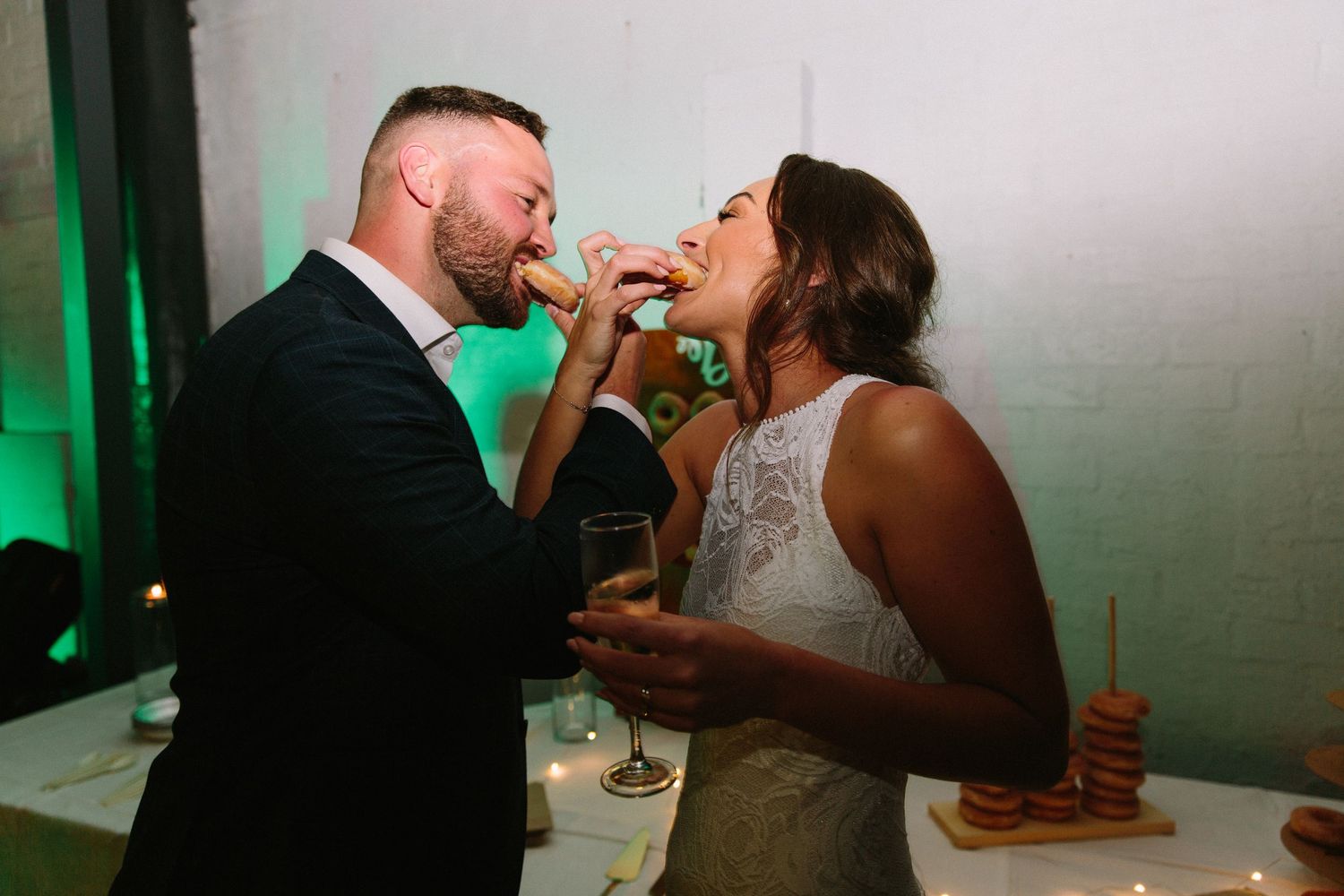 Wedding reception scene with green lighting and couples sharing intimate moments.